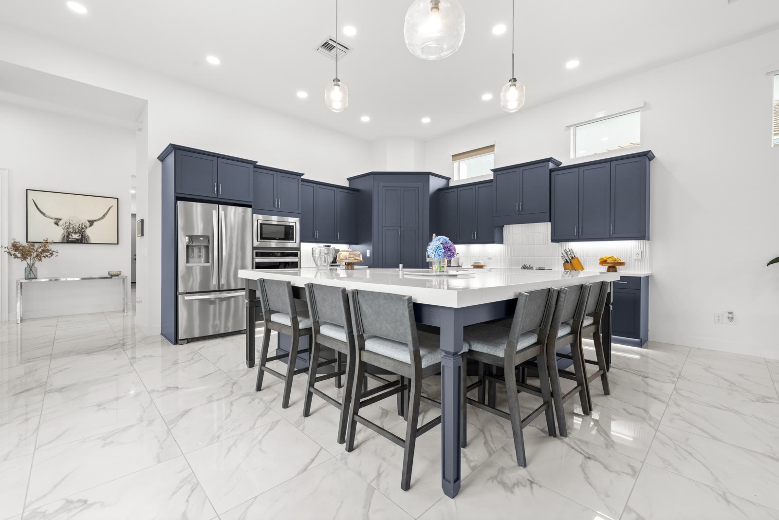 Navy blue kitchen with stainless appliances and marble countertops