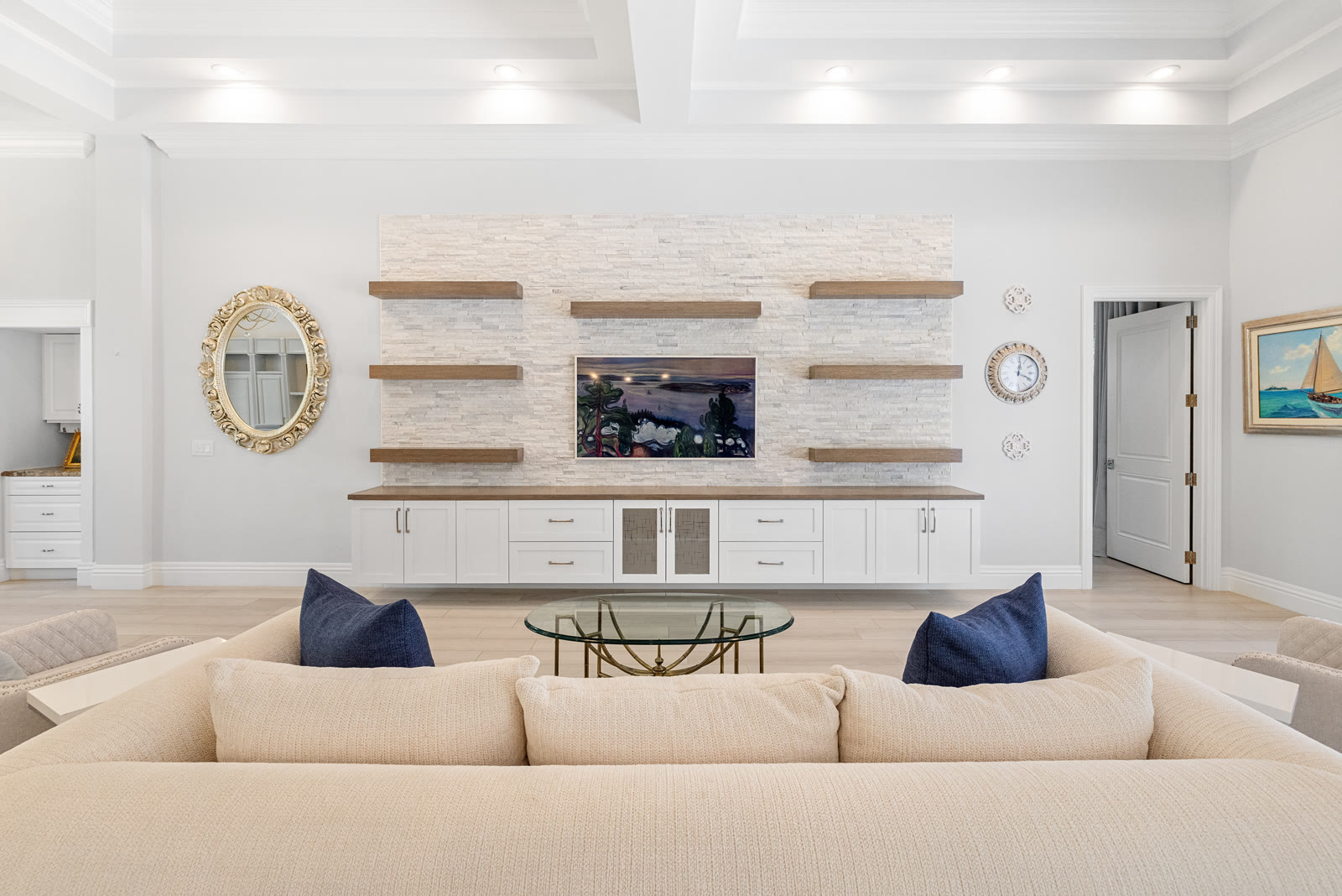 Family room with custom stone built-in wall, floating shelves, and coastal decor