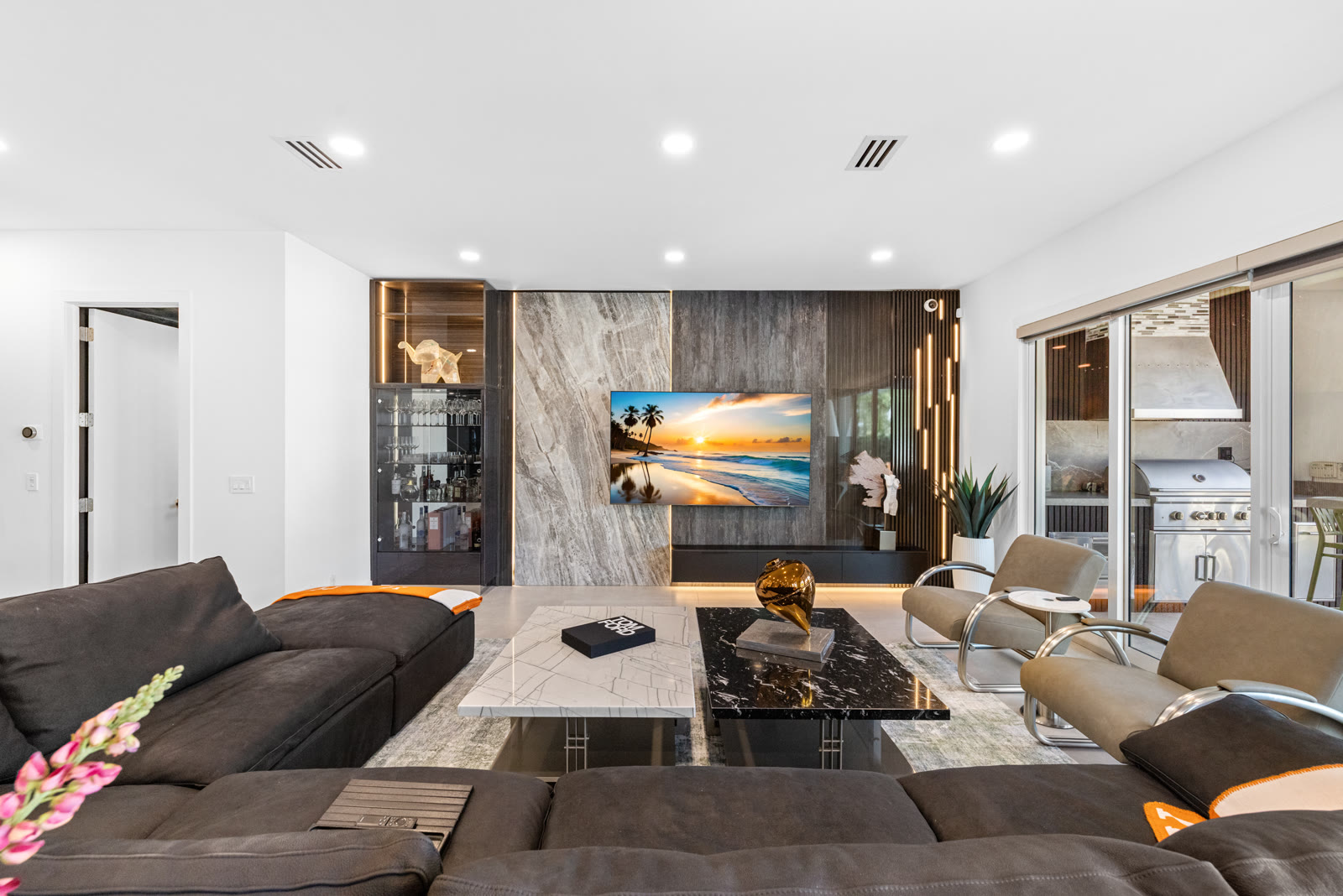 Living room with stone media wall and mounted TV in a Boca Raton home
