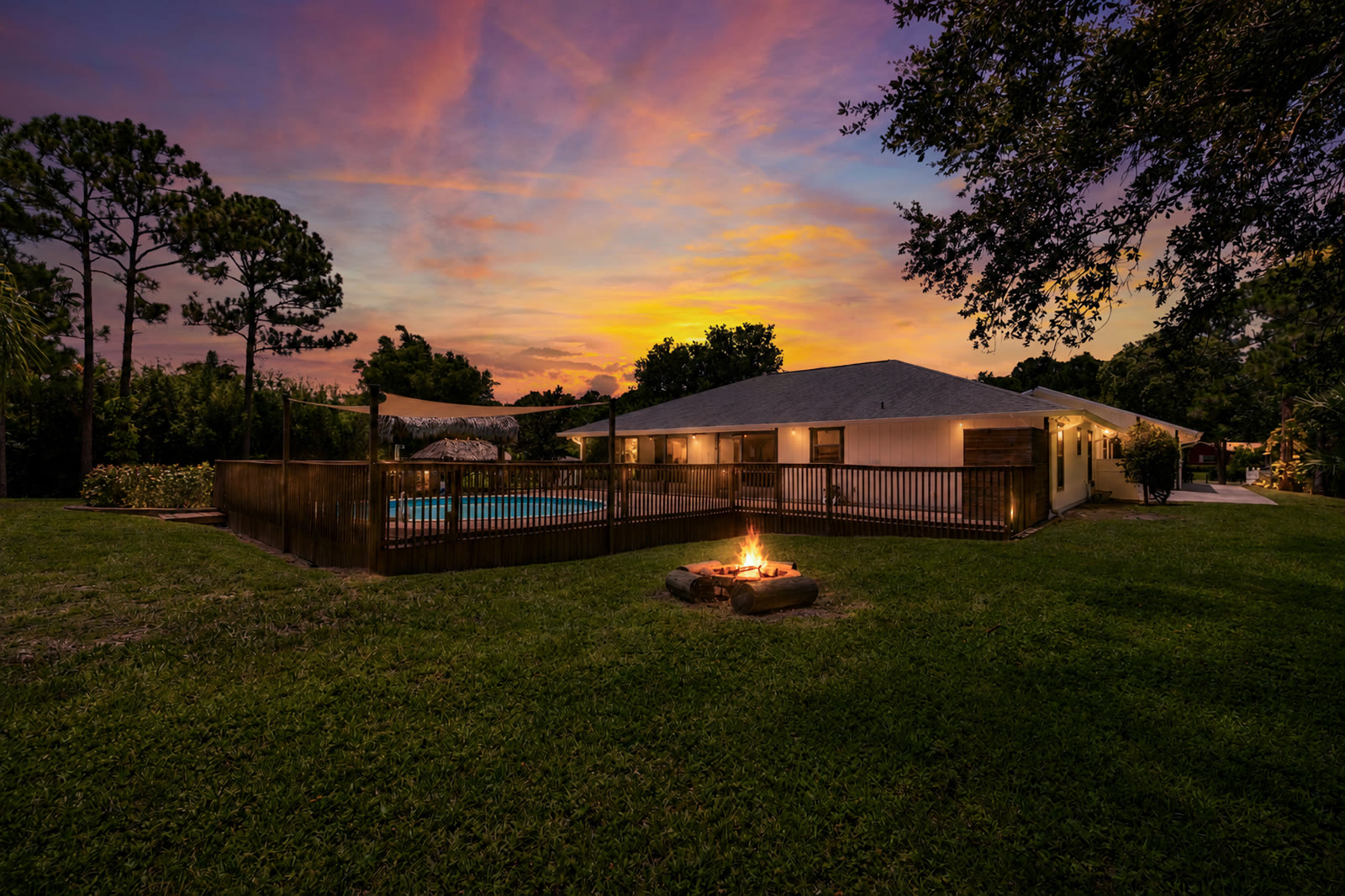 Twilight exterior photograph of a Jupiter Farms, FL home with pool and fire pit