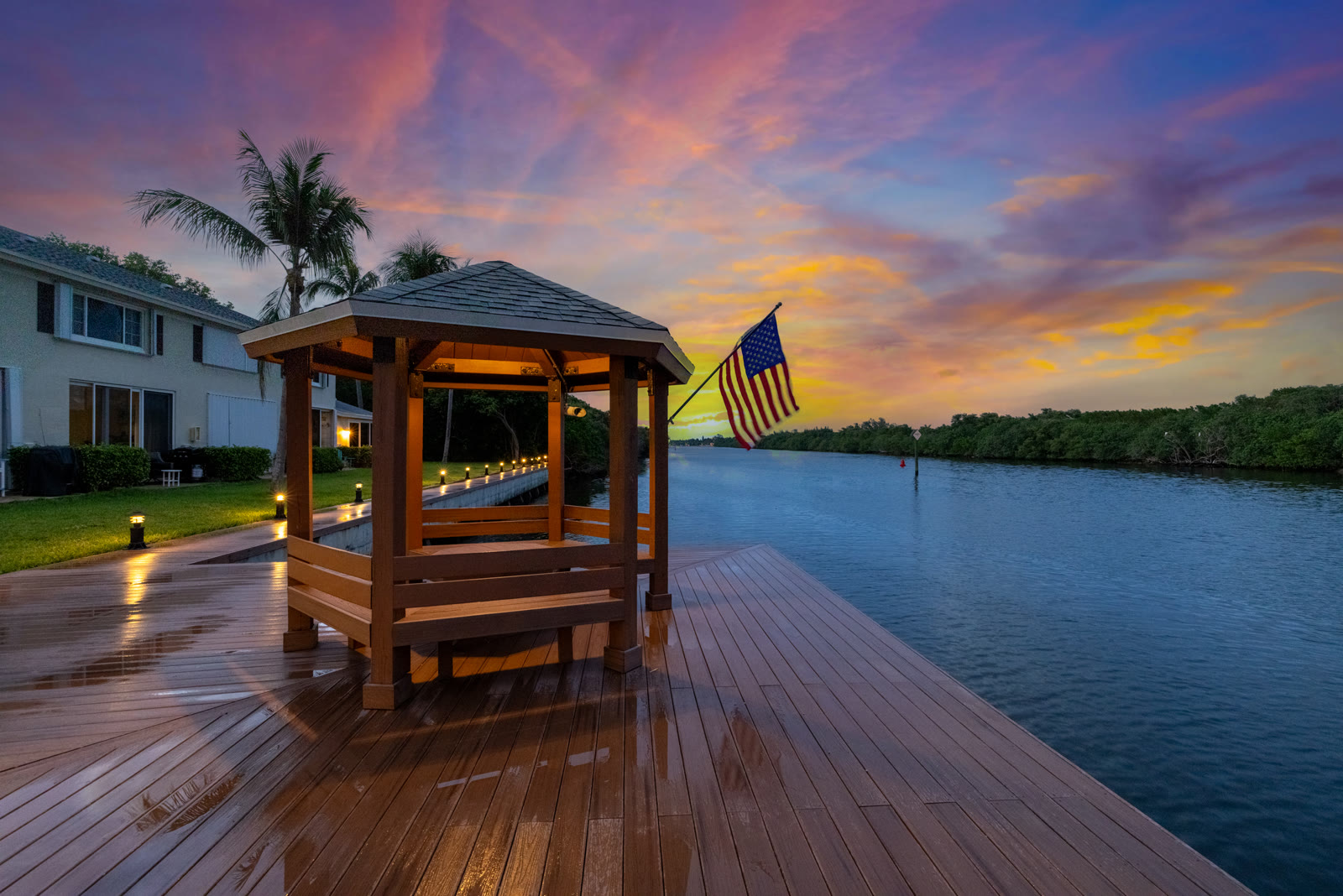 Twilight photograph of a private pool and outdoor living space at a South Florida luxury estate